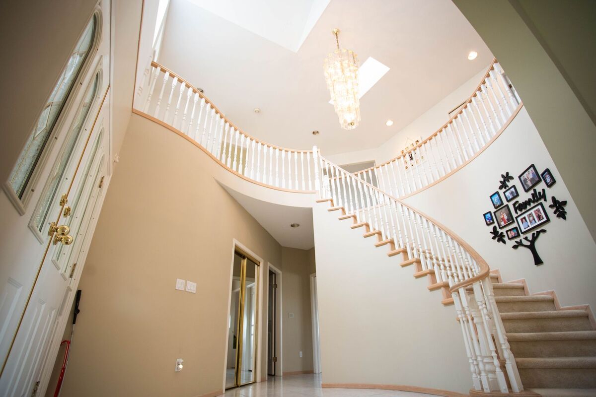 Two-storey foyer with a chandelier above a curved staircase